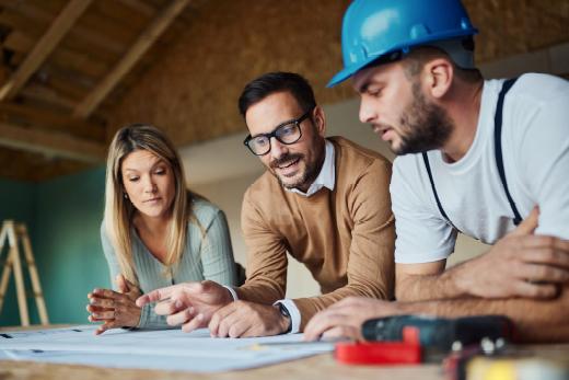 Paar mit Handwerker besprechen Bauplan