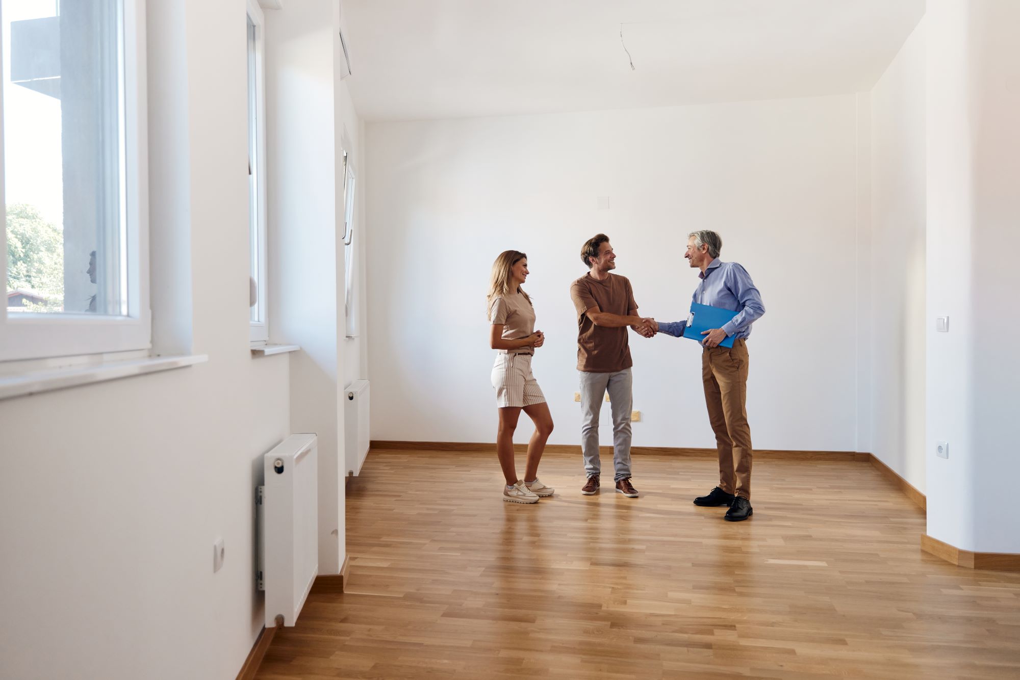 Junges Paar schüttelt die Hand mit Makler